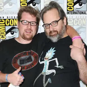 Justin Roiland posing with Rick and Morty's animated characters in the background. 