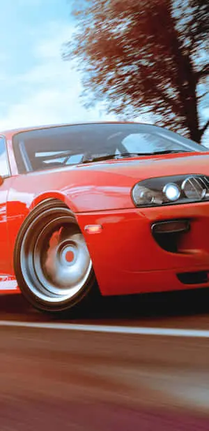 a red car driving down the road